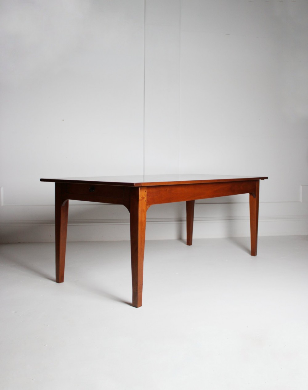 A rectangular French cherrywood dining table featuring tapered legs, a plain apron, and an end drawer with a dark circular pull knob. View VII