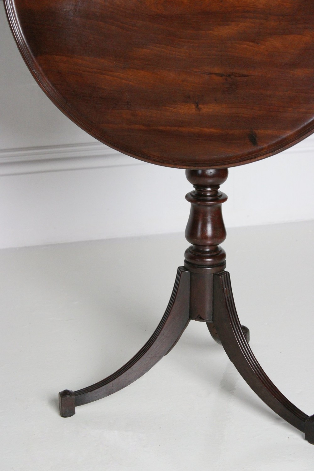 An antique Regency mahogany wine table featuring a rounded dish top on a turned pedestal stem and tripod splayed legs. View III