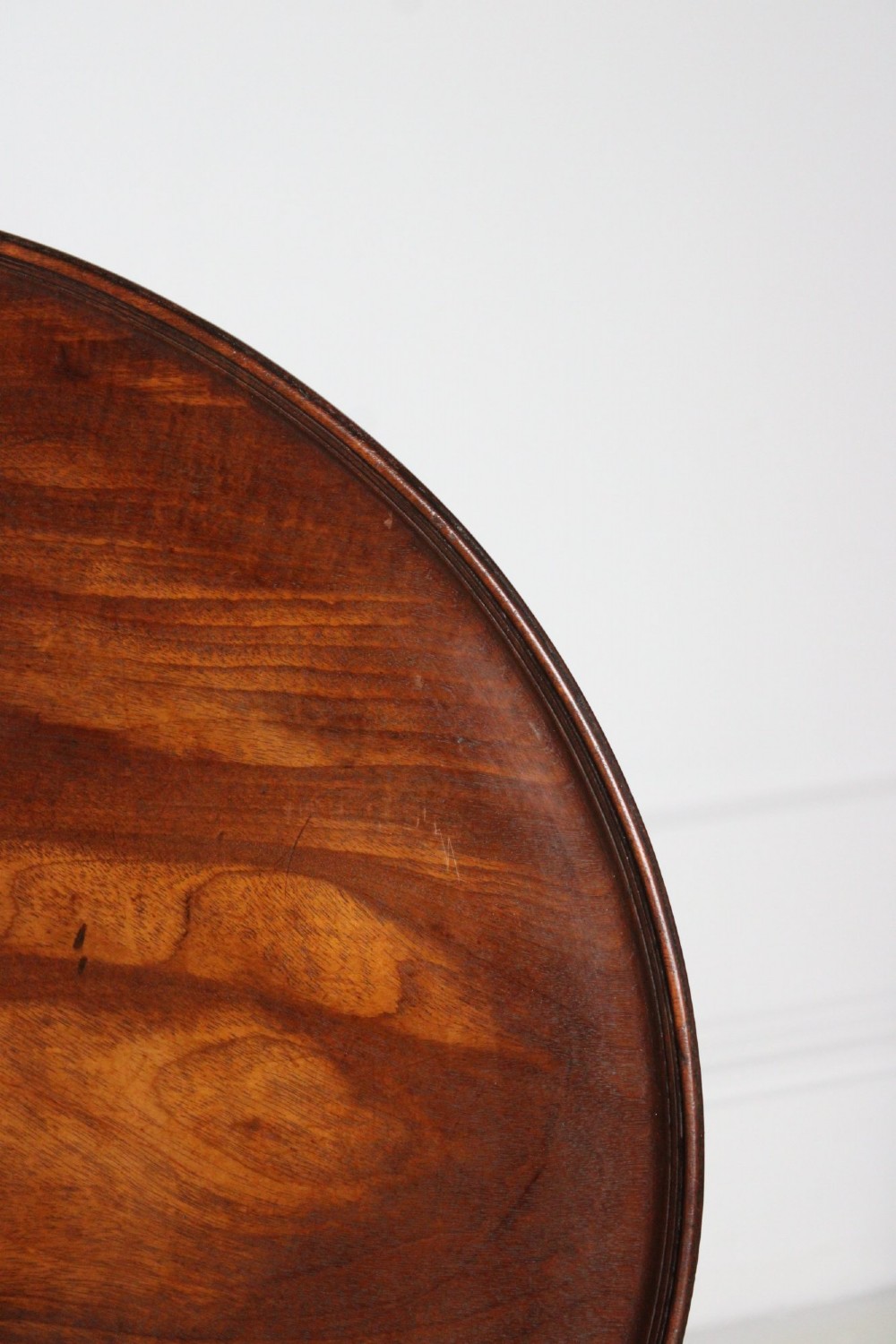 An antique Regency mahogany wine table featuring a rounded dish top on a turned pedestal stem and tripod splayed legs. View VIII