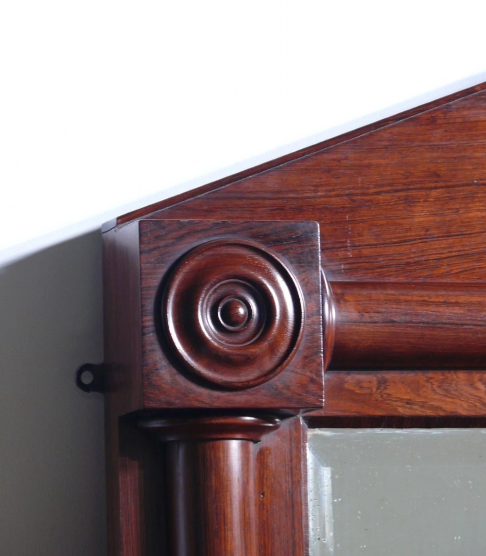 A 19th-century rosewood overmantel mirror featuring a pediment top and turned side columns with carved roundel capitals. View II