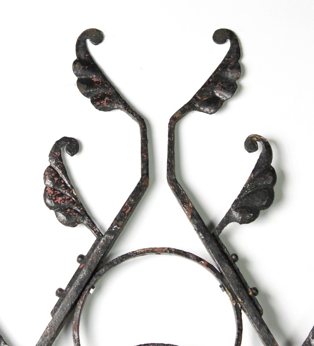A tall Victorian Gothic Revival iron arch with a pointed apex, decorative crockets along the outer edges, and circular tracery within the upper pediment. View IV