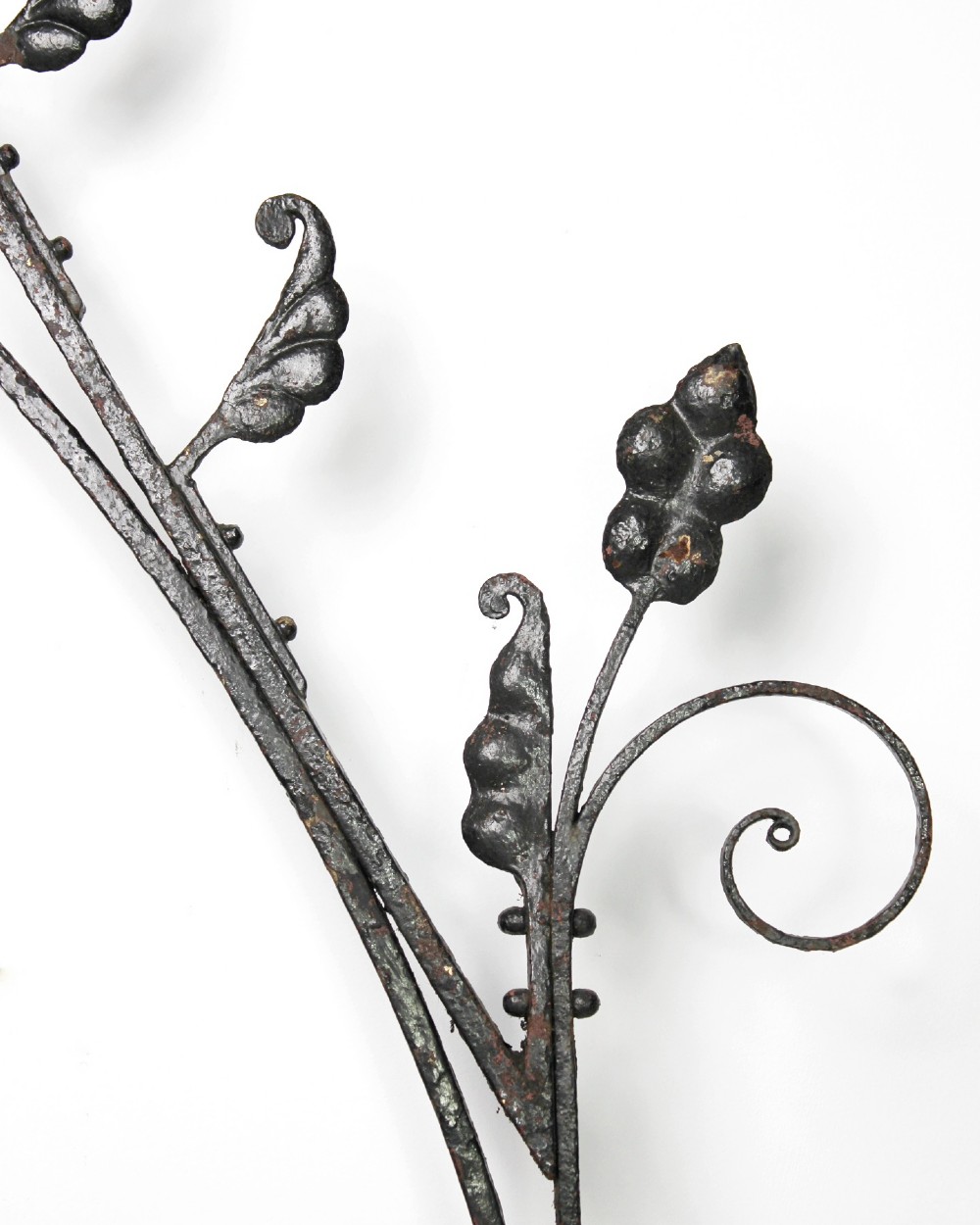 A tall Victorian Gothic Revival iron arch with a pointed apex, decorative crockets along the outer edges, and circular tracery within the upper pediment. View VII
