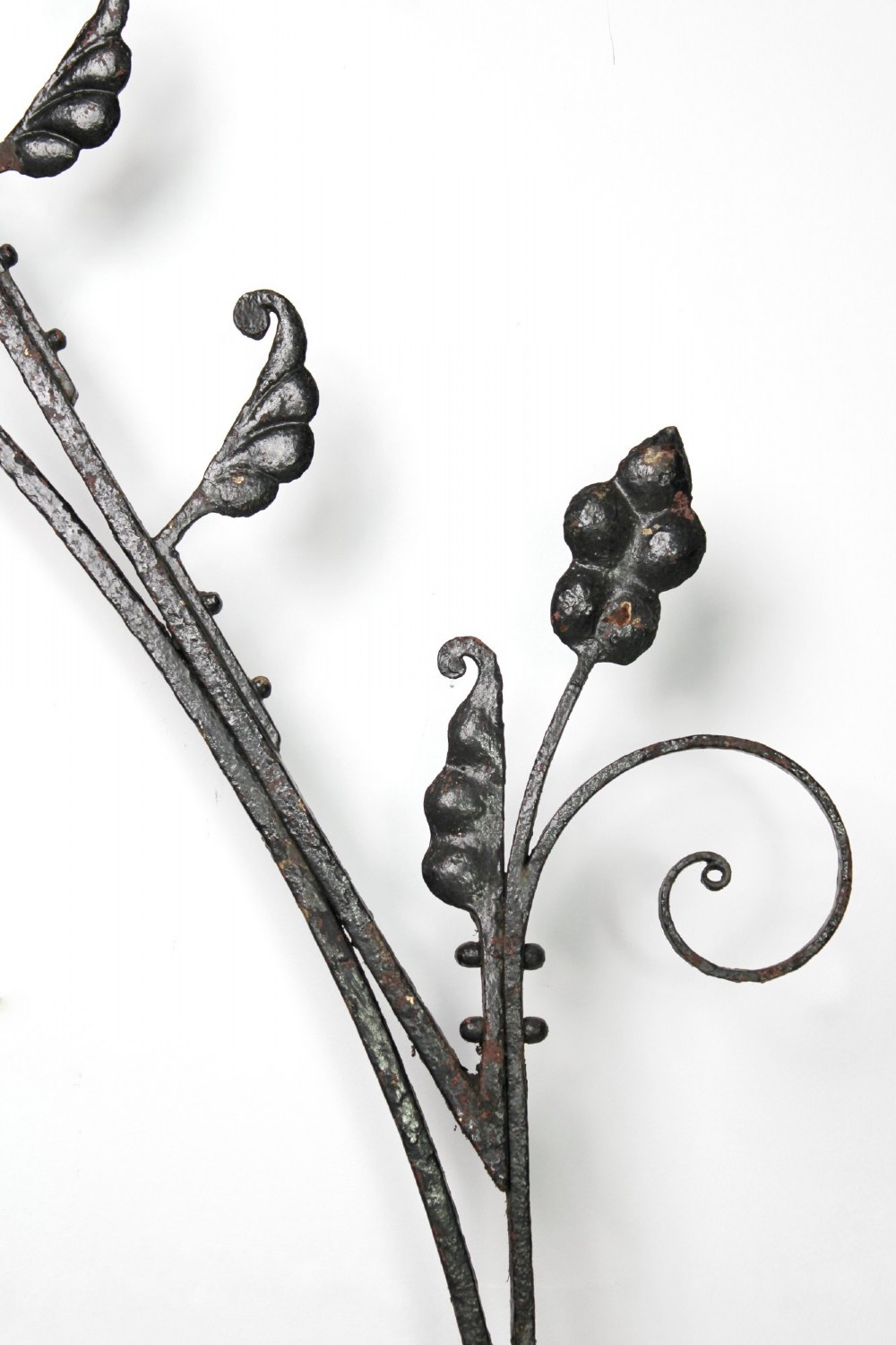A tall Victorian Gothic Revival iron arch with a pointed apex, decorative crockets along the outer edges, and circular tracery within the upper pediment. View X