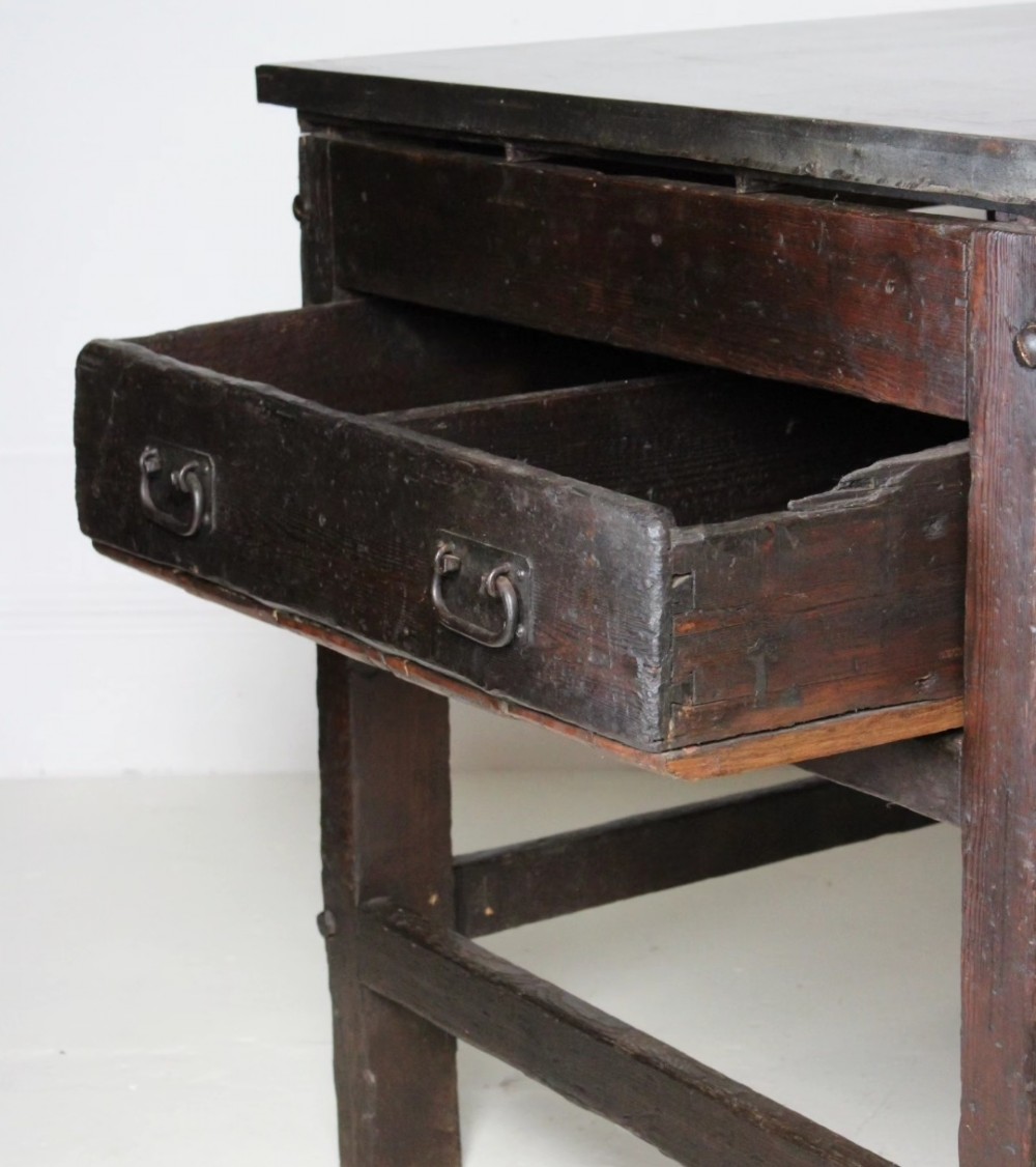A heavy Victorian dark wood industrial typesetting table featuring a flat metal surface, deep storage drawers, and robust square legs. View VII