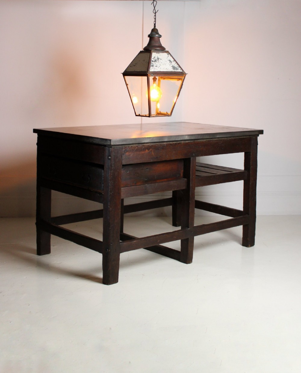 A heavy Victorian dark wood industrial typesetting table featuring a flat metal surface, deep storage drawers, and robust square legs. View VIII