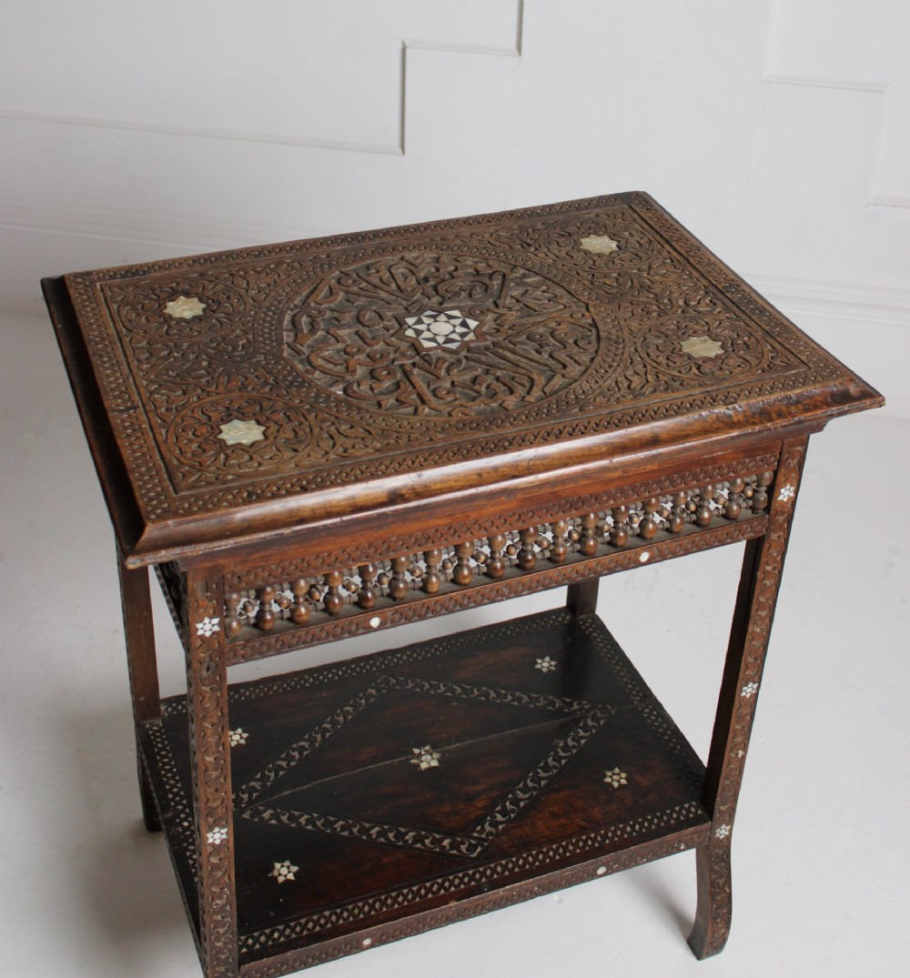 A 19th-century two-tier Syrian side table made from dark walnut with geometric mother-of-pearl inlay and carved openwork lattice panels. View V