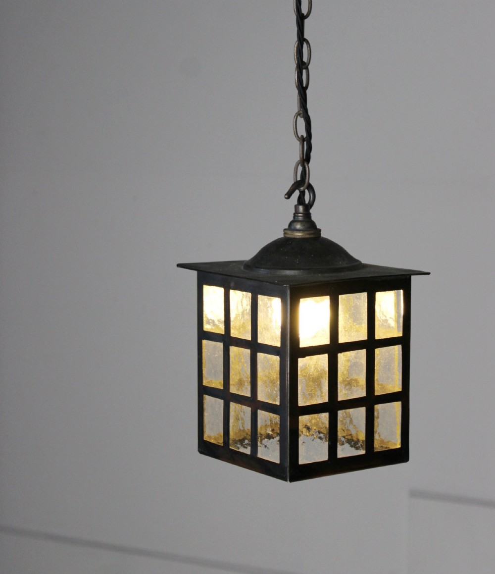 A square dark copper lantern featuring grid-pattern glazed sides with textured glass, hanging from a metal chain. View II