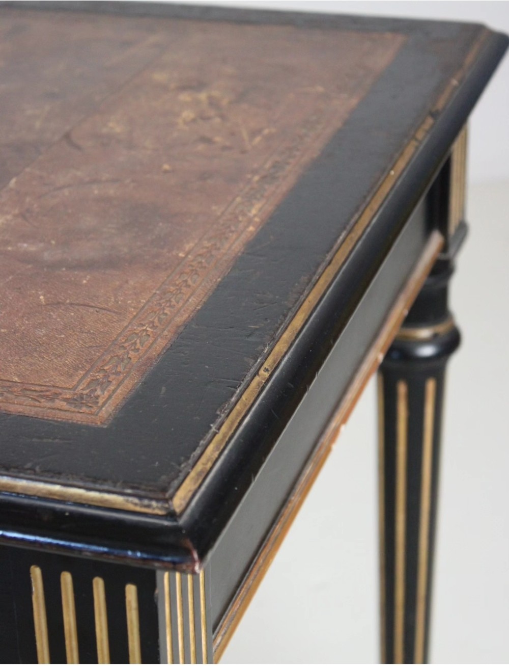 An ebonised Aesthetic Movement library writing table featuring gilt fluted legs, brass castors, and a leather inset top. View VII