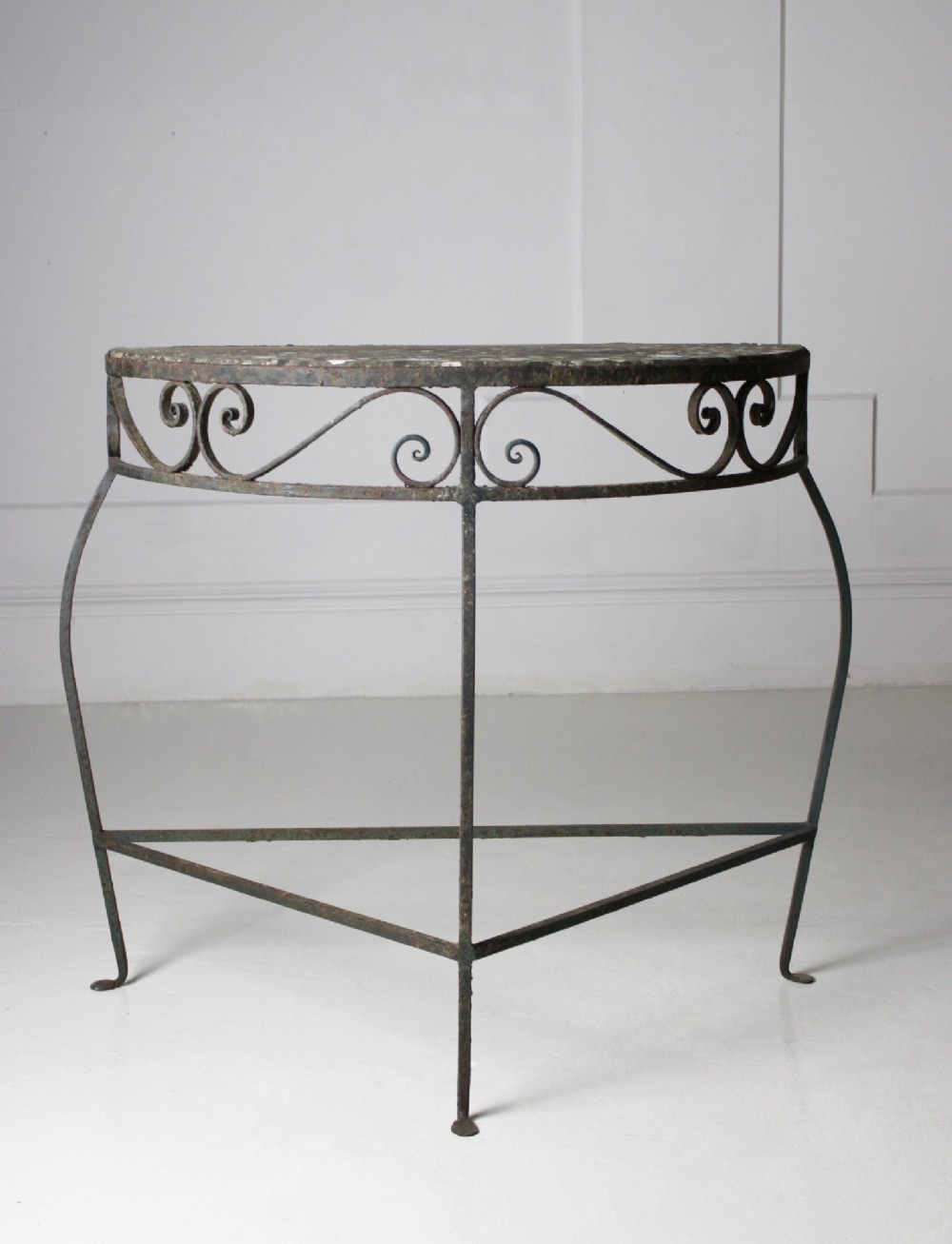 A demilune wrought iron console table featuring scrollwork decoration along the apron and a weathered dark marble top. View II