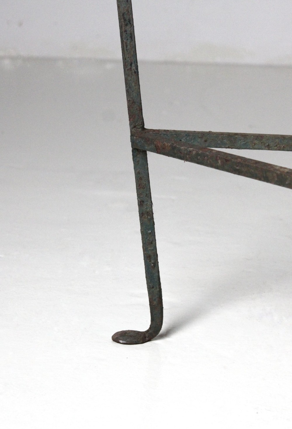 A demilune wrought iron console table featuring scrollwork decoration along the apron and a weathered dark marble top. View V
