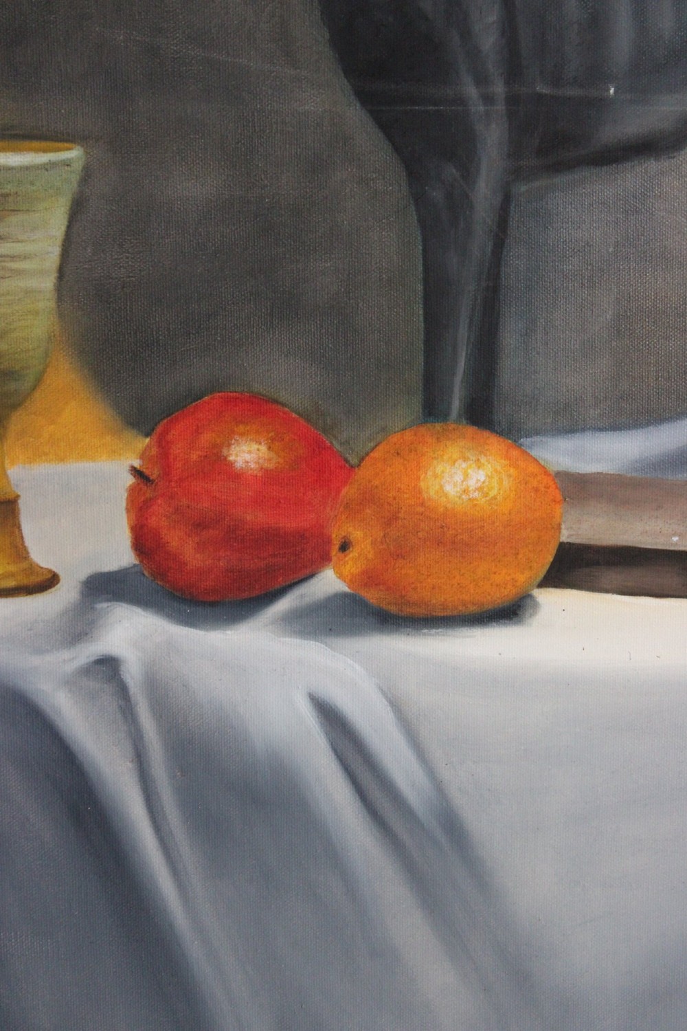 A large mid-20th-century oil painting depicting a draped tabletop still life with fruit, ceramic vessels, and a dark greyhound sculpture against a yellow and grey backdrop. View IV