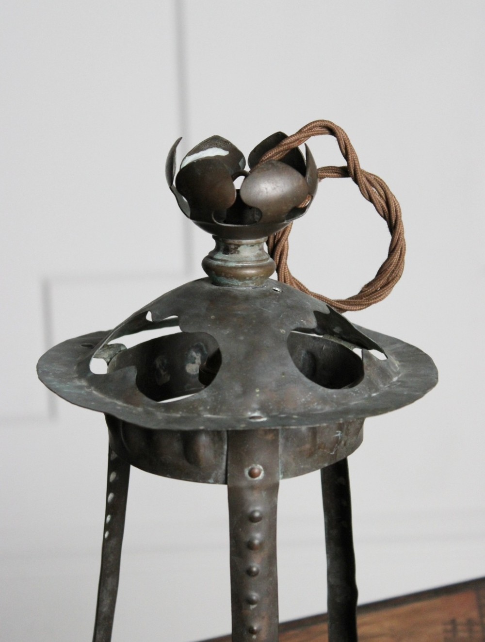 A hand-hammered Arts and Crafts copper porch lantern featuring riveted vertical straps, cut-out vents on the dome top, and a flower-shaped finial. View II