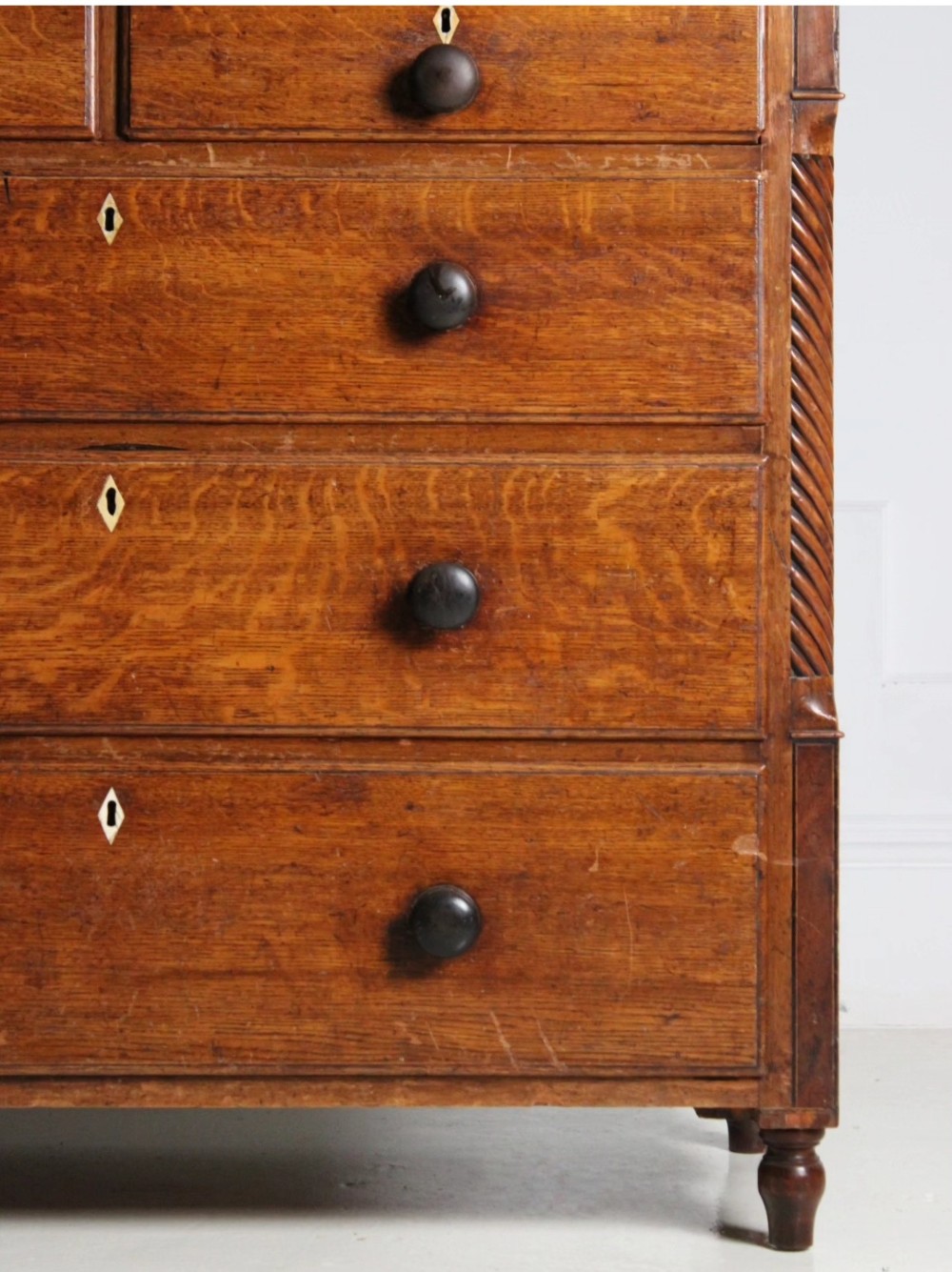 A large Georgian oak housekeepers cupboard featuring an upper two-door cabinet with raised panel doors atop a lower chest of drawers with turned wooden knobs. View III