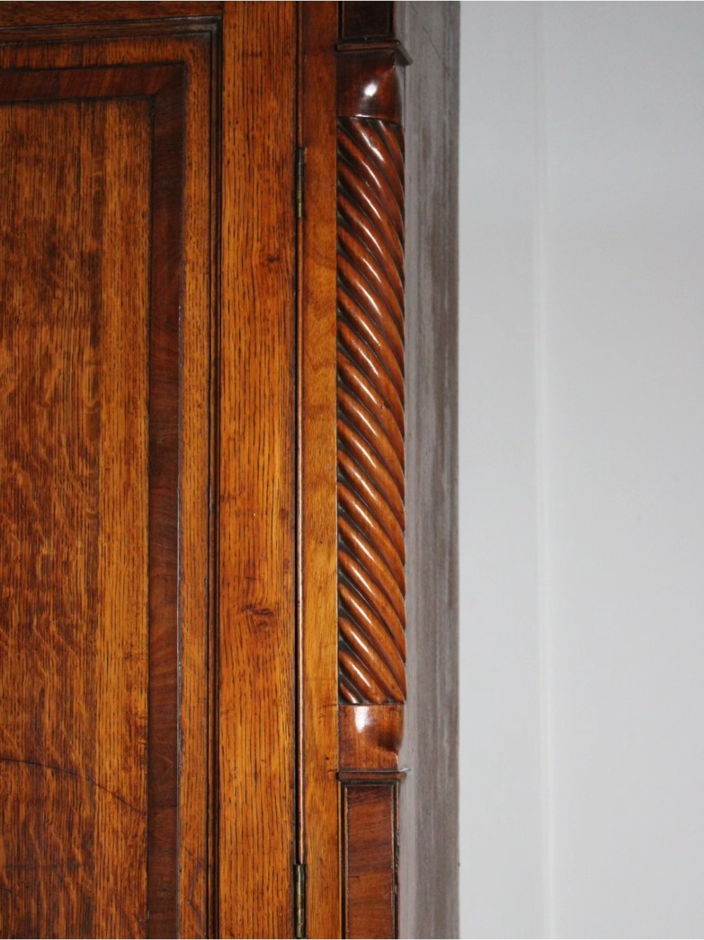 A large Georgian oak housekeepers cupboard featuring an upper two-door cabinet with raised panel doors atop a lower chest of drawers with turned wooden knobs. View V