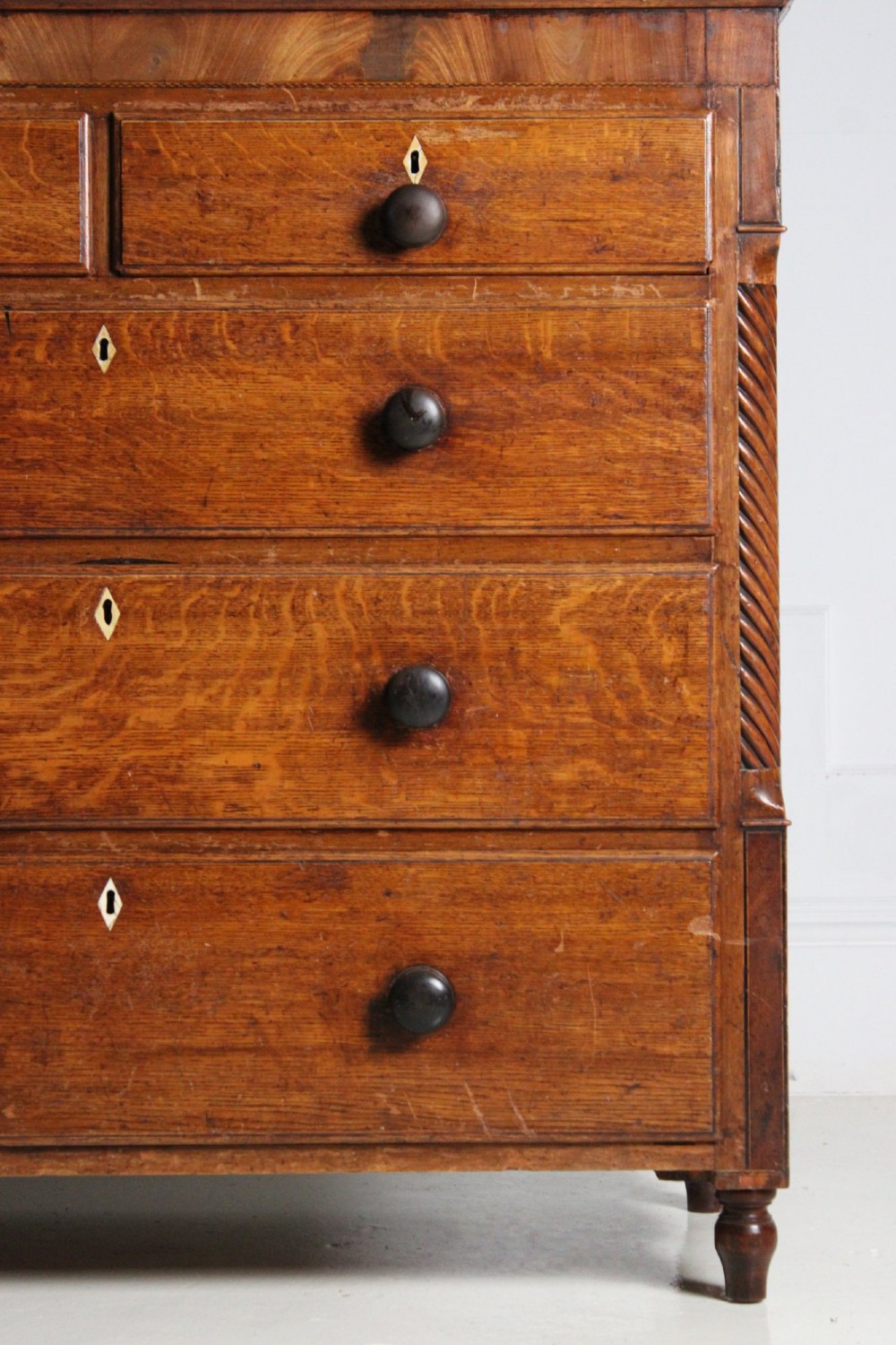A large Georgian oak housekeepers cupboard featuring an upper two-door cabinet with raised panel doors atop a lower chest of drawers with turned wooden knobs. View VI