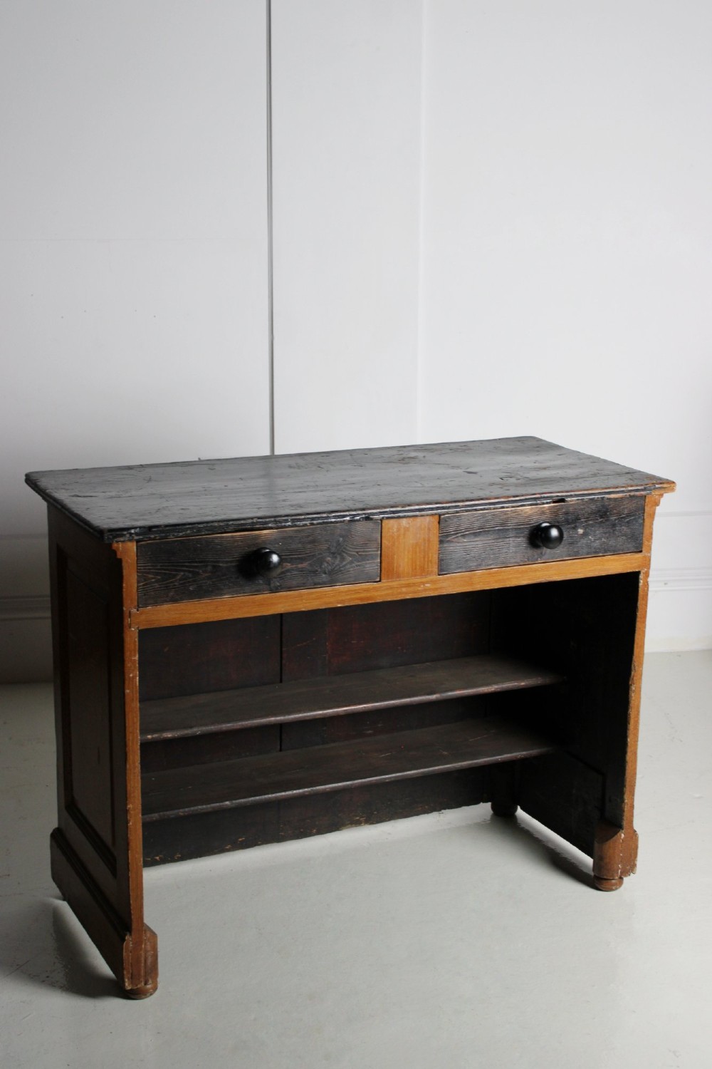 A Victorian painted pine shop counter featuring a scumbled faux oak finish, two large recessed front panels, and a low plinth base. View V