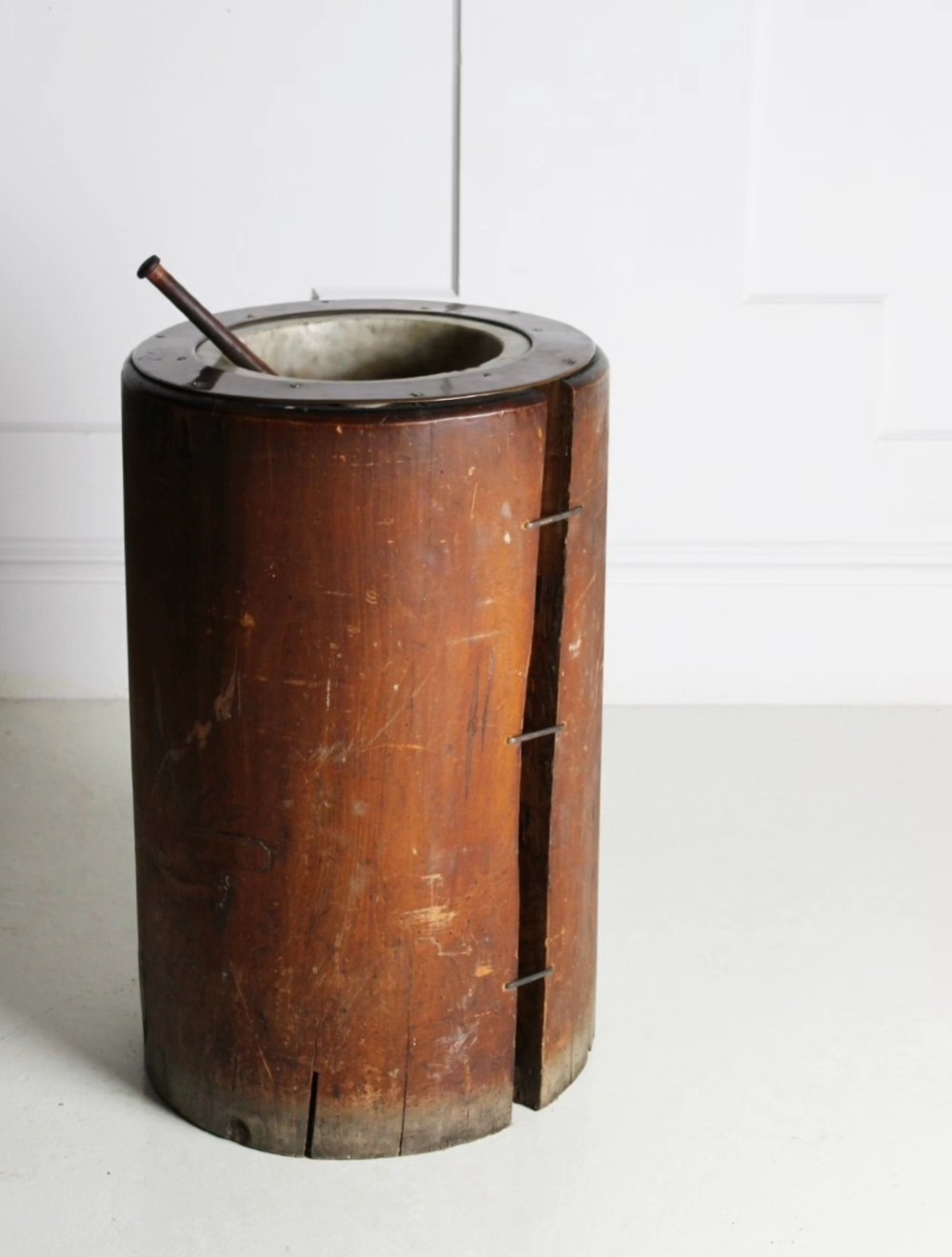 A late 19th-century floor-standing wooden mortar constructed from a hollowed trunk section with an inset stone basin and a pestle. View III