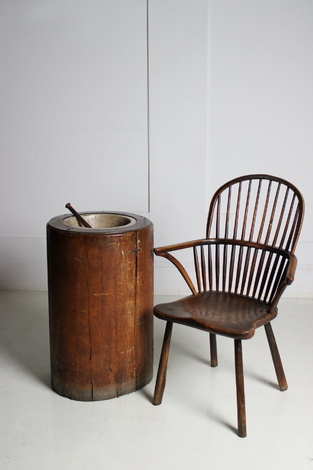 A late 19th-century floor-standing wooden mortar constructed from a hollowed trunk section with an inset stone basin and a pestle. View IV