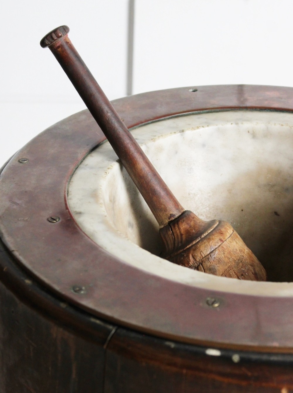 A late 19th-century floor-standing wooden mortar constructed from a hollowed trunk section with an inset stone basin and a pestle. View VI