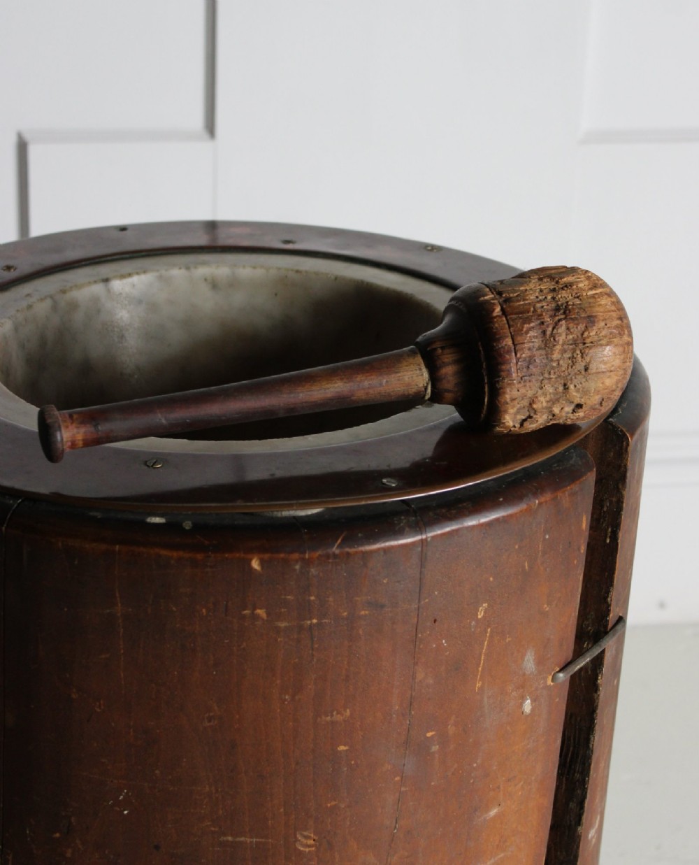 A late 19th-century floor-standing wooden mortar constructed from a hollowed trunk section with an inset stone basin and a pestle. View VII