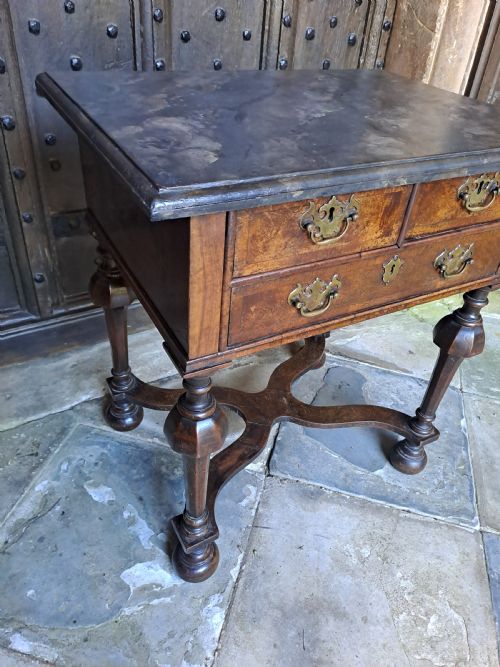 fig 1. A walnut side table featuring three drawers with brass handles, inverted cup turned legs, and a curved X-stretcher.