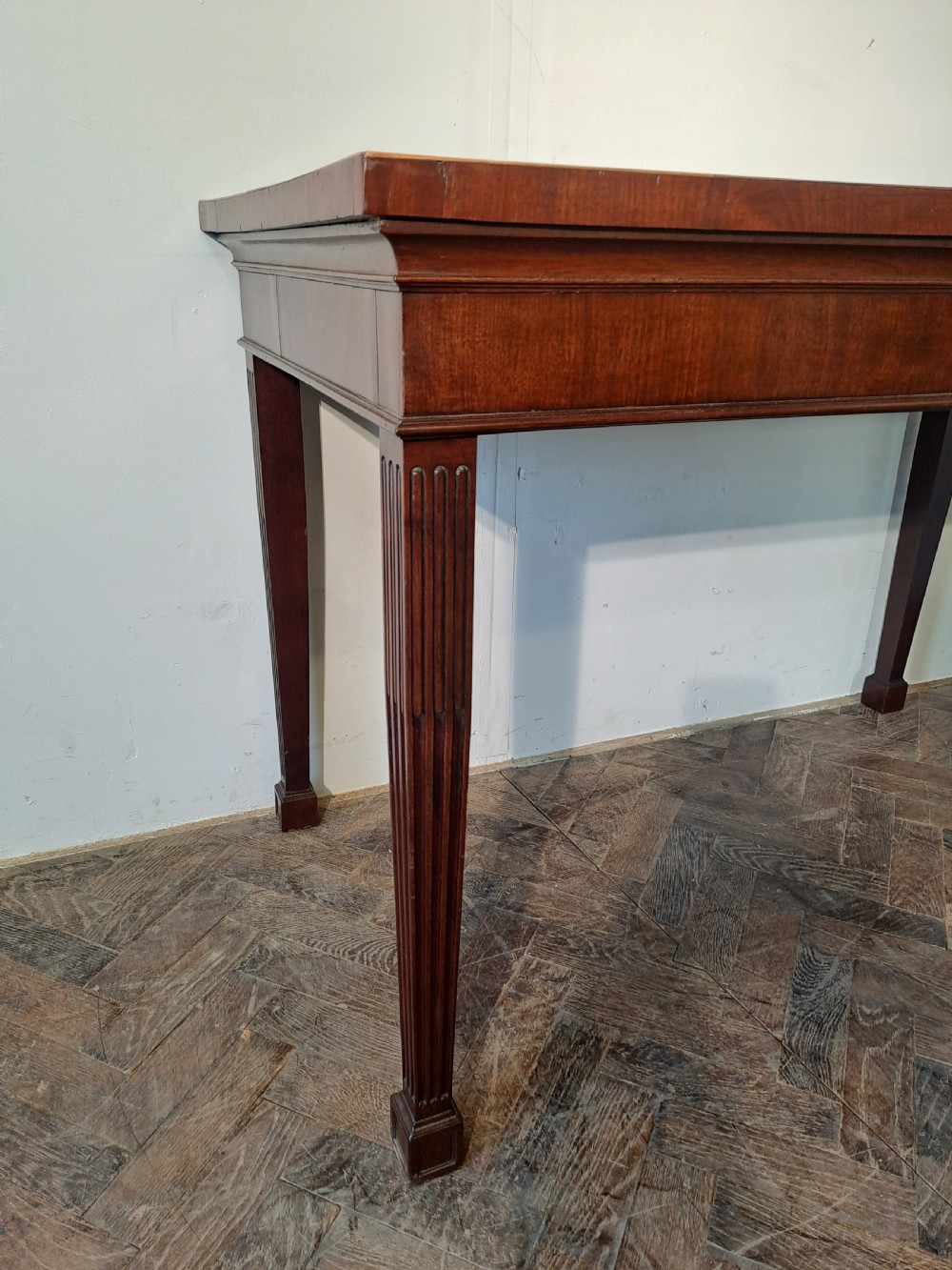 A Georgian dark mahogany rectangular console table featuring fluted square tapered legs and subtle top line inlay. View VI