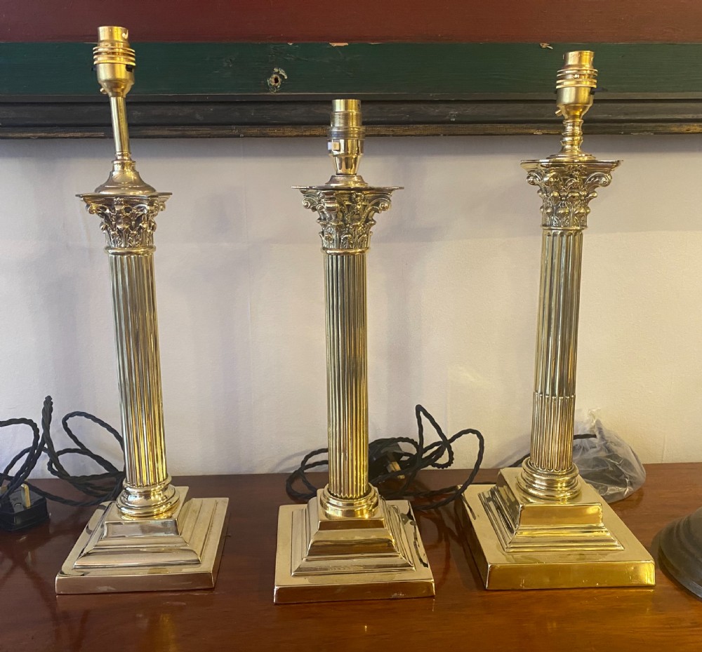 Three edwardian Brass corinthian column lamps 