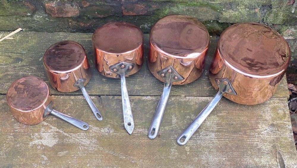 A harlequin set of 5 copper saucepans some with makers marks one for Harrods  View V