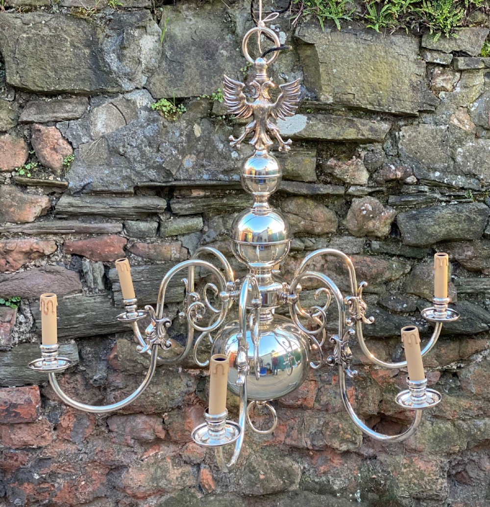 A six-arm silver-plated brass Dutch-style chandelier featuring a cresting eagle finial, baluster stem, spherical base drop, and candle-style light sockets. View VII