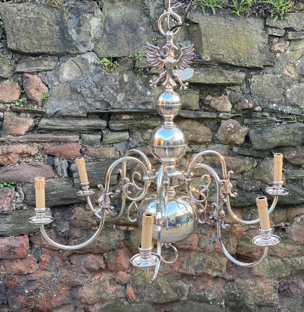 A six-arm silver-plated brass Dutch-style chandelier featuring a cresting eagle finial, baluster stem, spherical base drop, and candle-style light sockets. View VIII