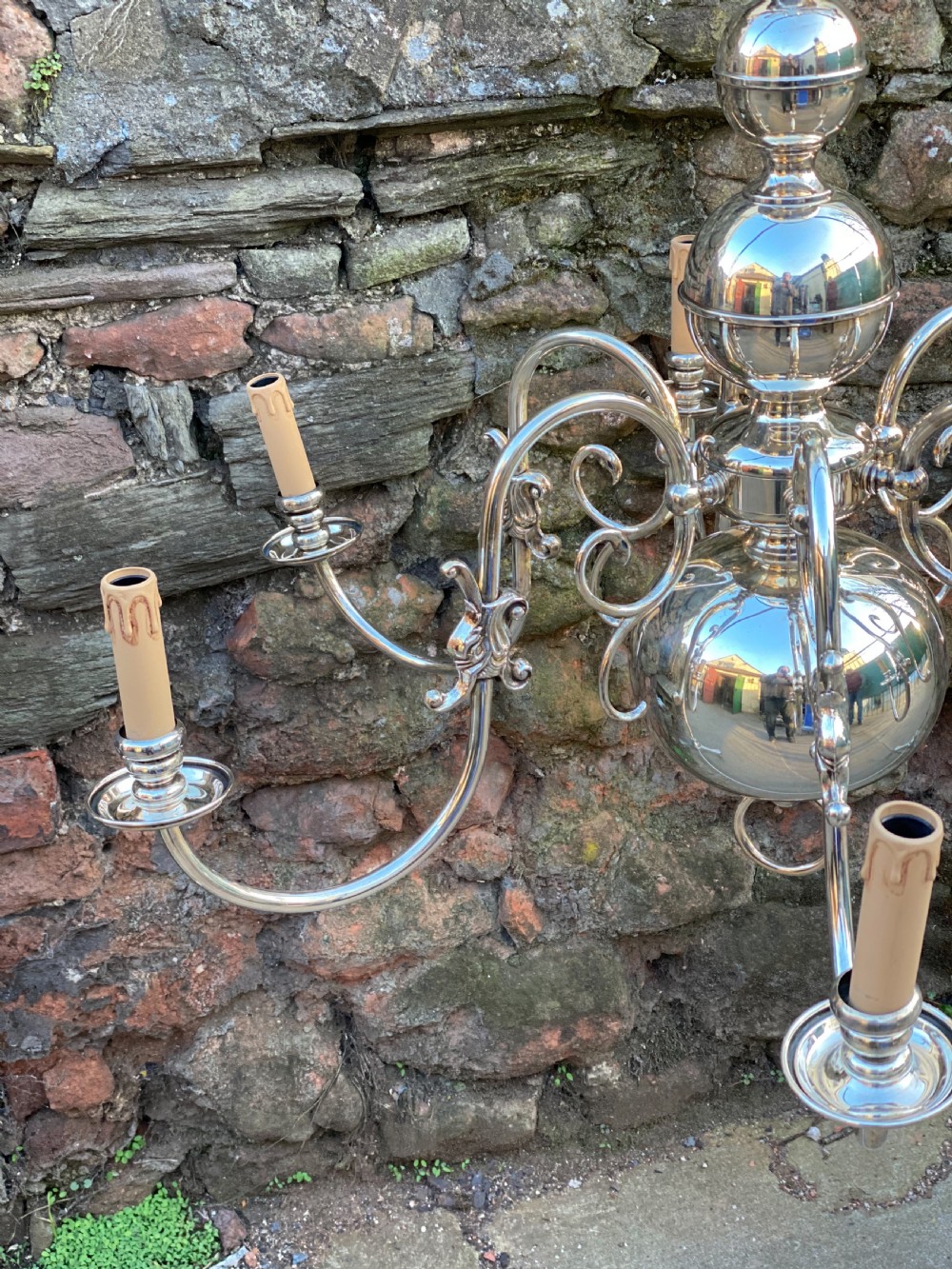 A six-arm silver-plated brass Dutch-style chandelier featuring a cresting eagle finial, baluster stem, spherical base drop, and candle-style light sockets. View IX