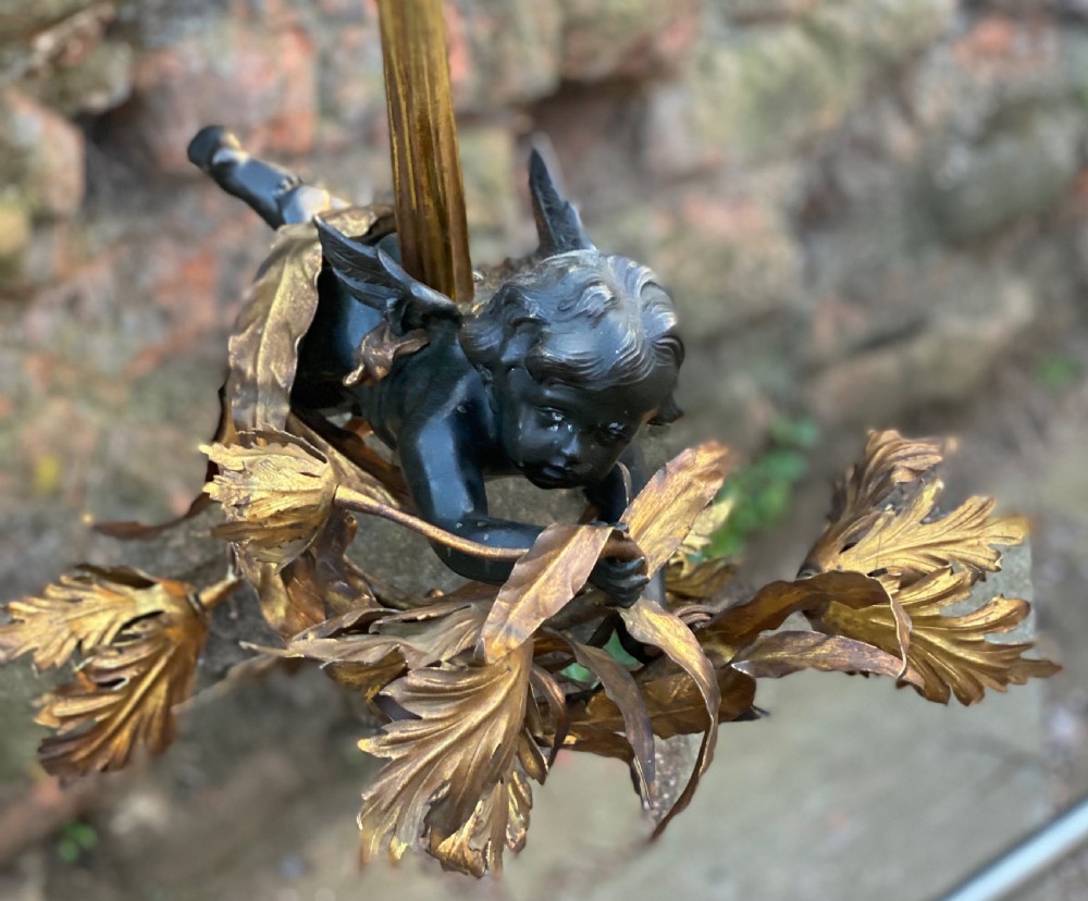 A large three light ceiling light depicting a bronze cherub flying  View X