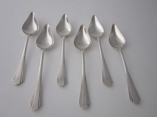 fig 1. A set of six sterling silver grapefruit spoons with pointed bowls and stepped handles presented inside a fitted black velvet case.