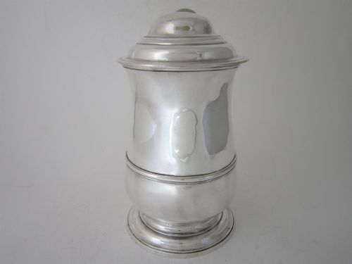 fig 2. An antique George III sterling silver lidded tankard featuring a moulded dome lid, scroll handle, central girdle band, and spreading base.
