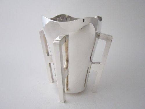 fig 1. An Edwardian sterling silver mether cup featuring a square mouth and four angular handles that extend downward to form the feet.