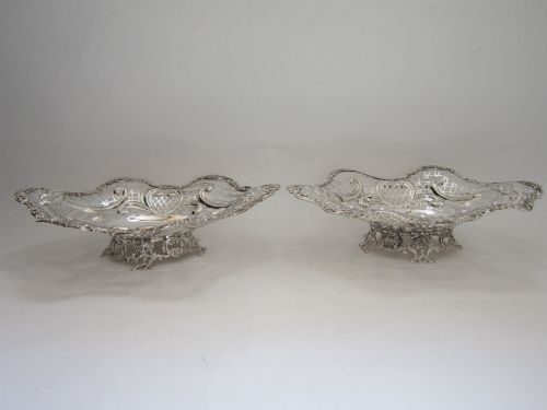 fig 1. A pair of late Victorian sterling silver dishes featuring intricate pierced lattice pattern, ornate scroll borders, and raised feet.