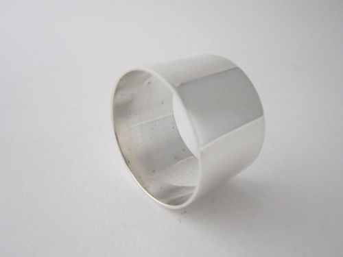fig 1. A plain cylindrical sterling silver napkin ring displaying a polished metallic finish.