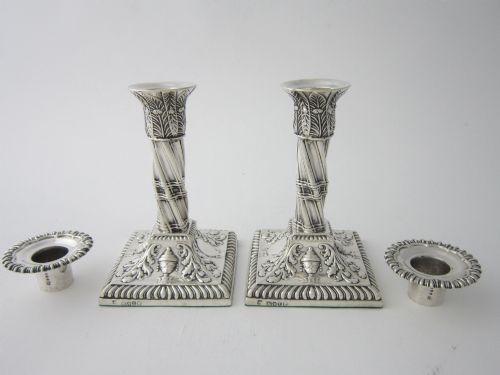 fig 1. Pair of 1884 Victorian sterling silver candlesticks featuring spiral fluted column stems and square bases embossed with urn and leaf motifs.