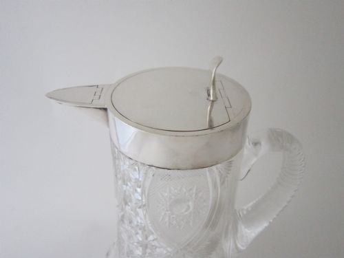 fig 1. A large George V cut glass jug featuring a sterling silver collar and spout alongside a moulded glass handle.