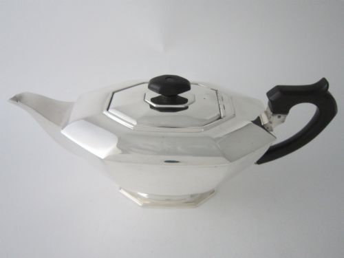 fig 1. An octagonal sterling silver teapot featuring an ebonised wooden handle and matching black lid finial.