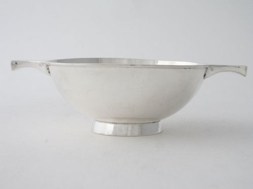 fig 2. A solid sterling silver Scottish quaich featuring a shallow circular bowl, two flat lateral handles, and a low raised foot.
