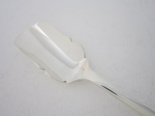 fig 1. A sterling silver Stilton scoop featuring a curved rectangular shovel blade and a smooth Old English pattern handle.