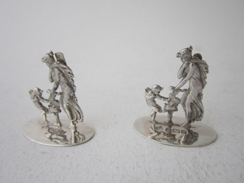 fig 1. A pair of Edwardian sterling silver place card holders featuring classical female figures and cherubs on round hallmarked bases.