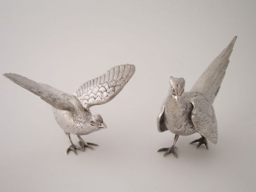 fig 2. A pair of detailed sterling silver pheasant figurines positioned on a plain background.
