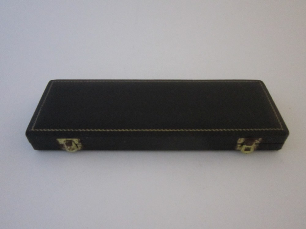 A pair of sterling silver lobster picks with embossed central medallions displayed inside an open black velvet-lined box. View III