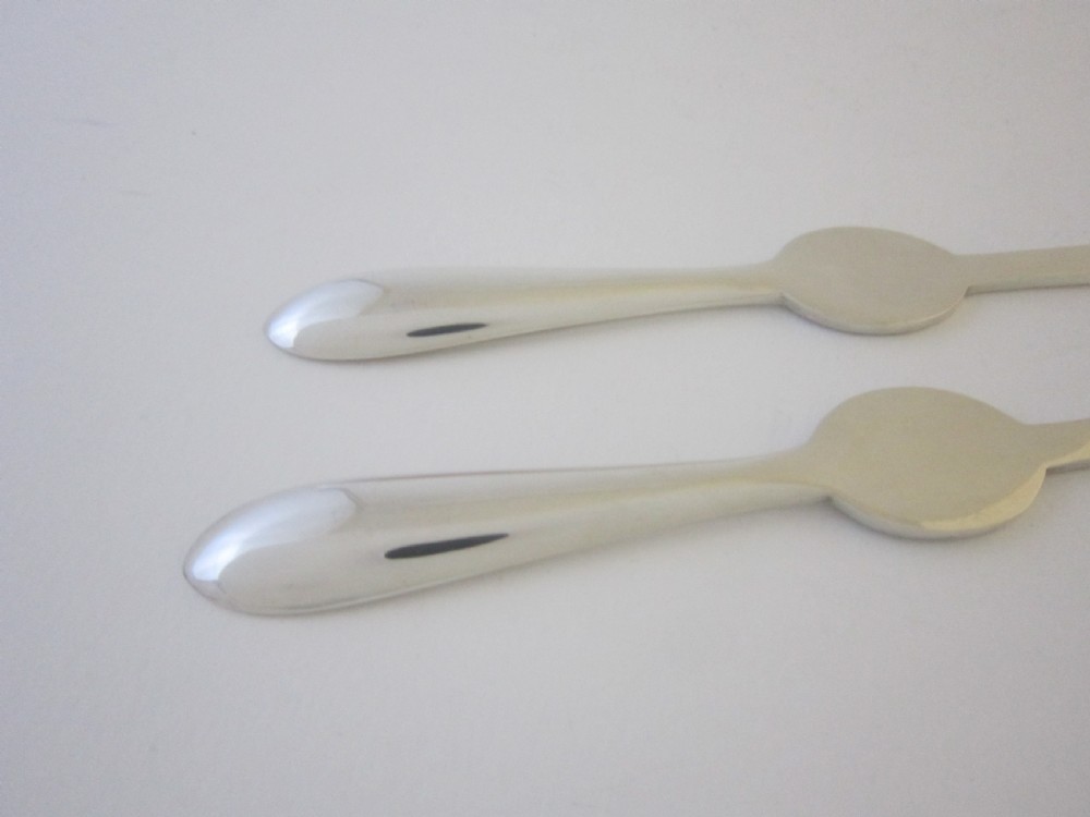 A pair of sterling silver lobster picks with embossed central medallions displayed inside an open black velvet-lined box. View XII
