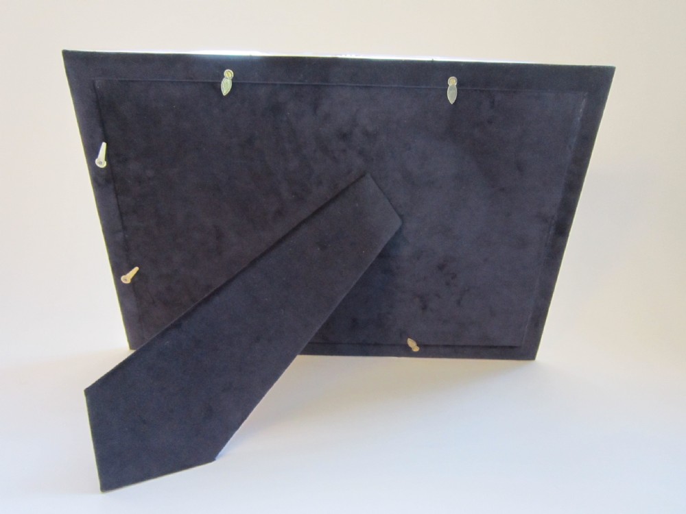 A large rectangular sterling silver picture frame with a simple moulded border and a grey fabric insert in a landscape alignment. View VII