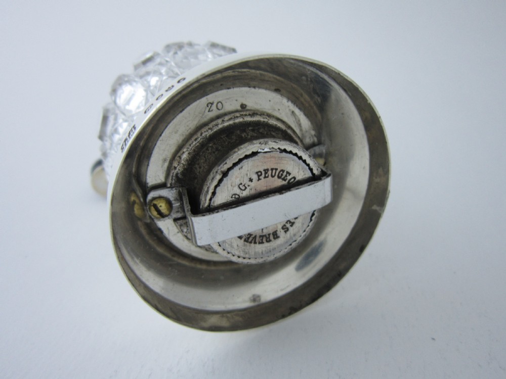 A Victorian sterling silver and cut glass pepper mill with a hand crank handle and hallmarked silver base. View V