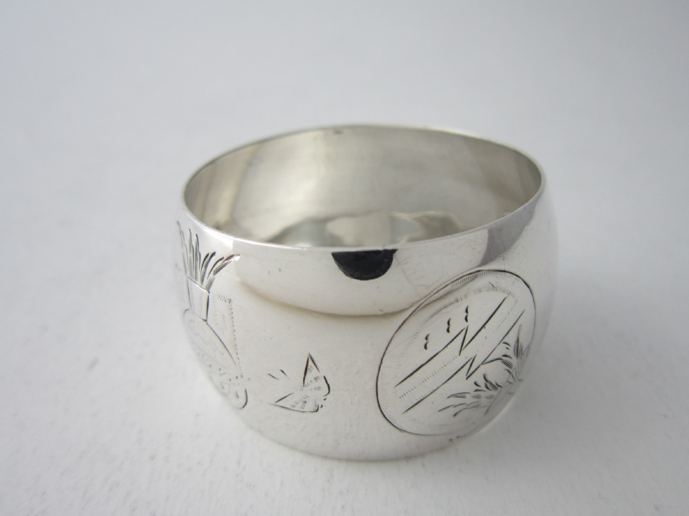 An antique late Victorian sterling silver napkin ring featuring hand-engraved foliate motifs and a polished finish. View III