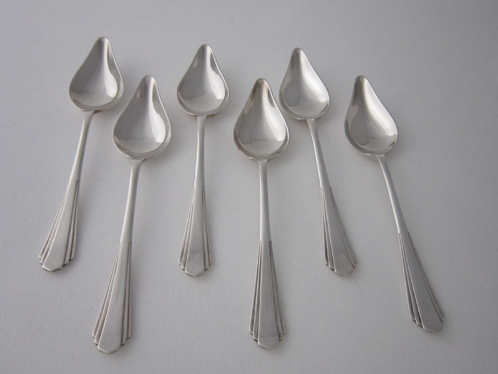 A set of six sterling silver grapefruit spoons with pointed bowls and stepped handles presented inside a fitted black velvet case. View II